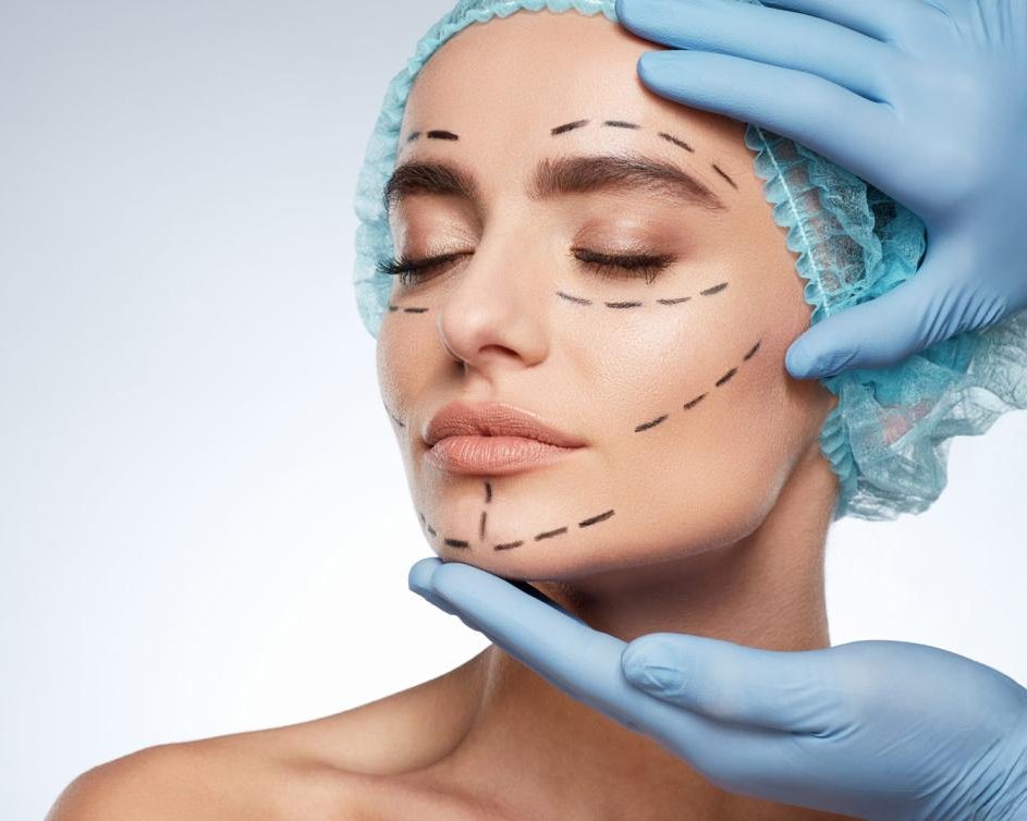 Surgeon's gloved hands framing a patient's face marked for surgery